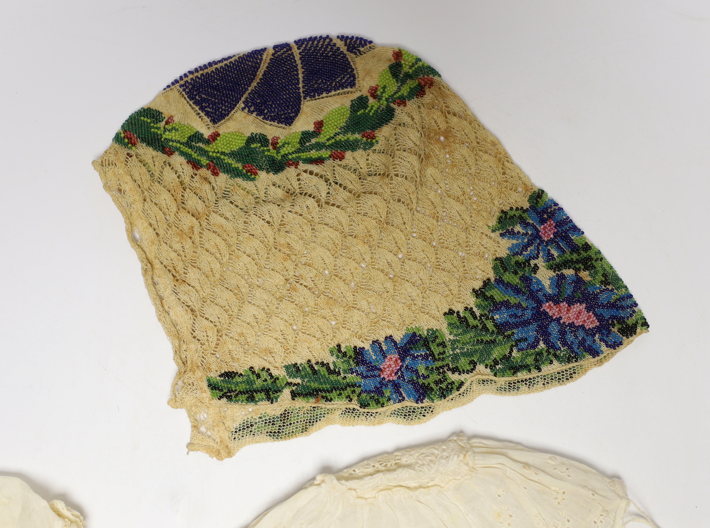 Seven baby bonnets, late 18th / 19th century, including a fine bobbin lace bonnet and unusual silk knitted and multi coloured floral designed beaded bonnet